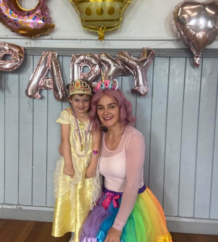 Entertainer with a child at a unicorn themed party